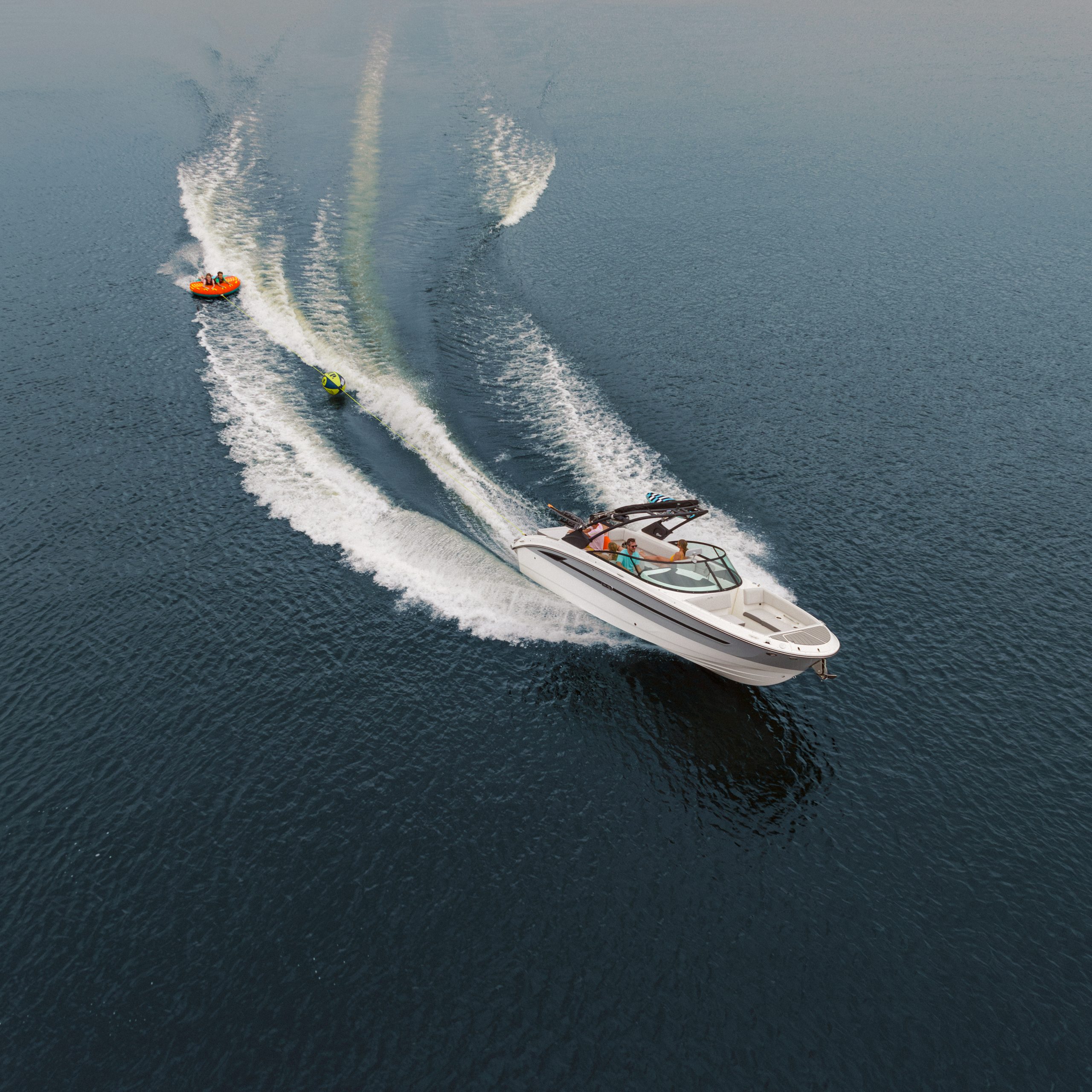 Aerial view of people tubing behind an SDX 270 Surf