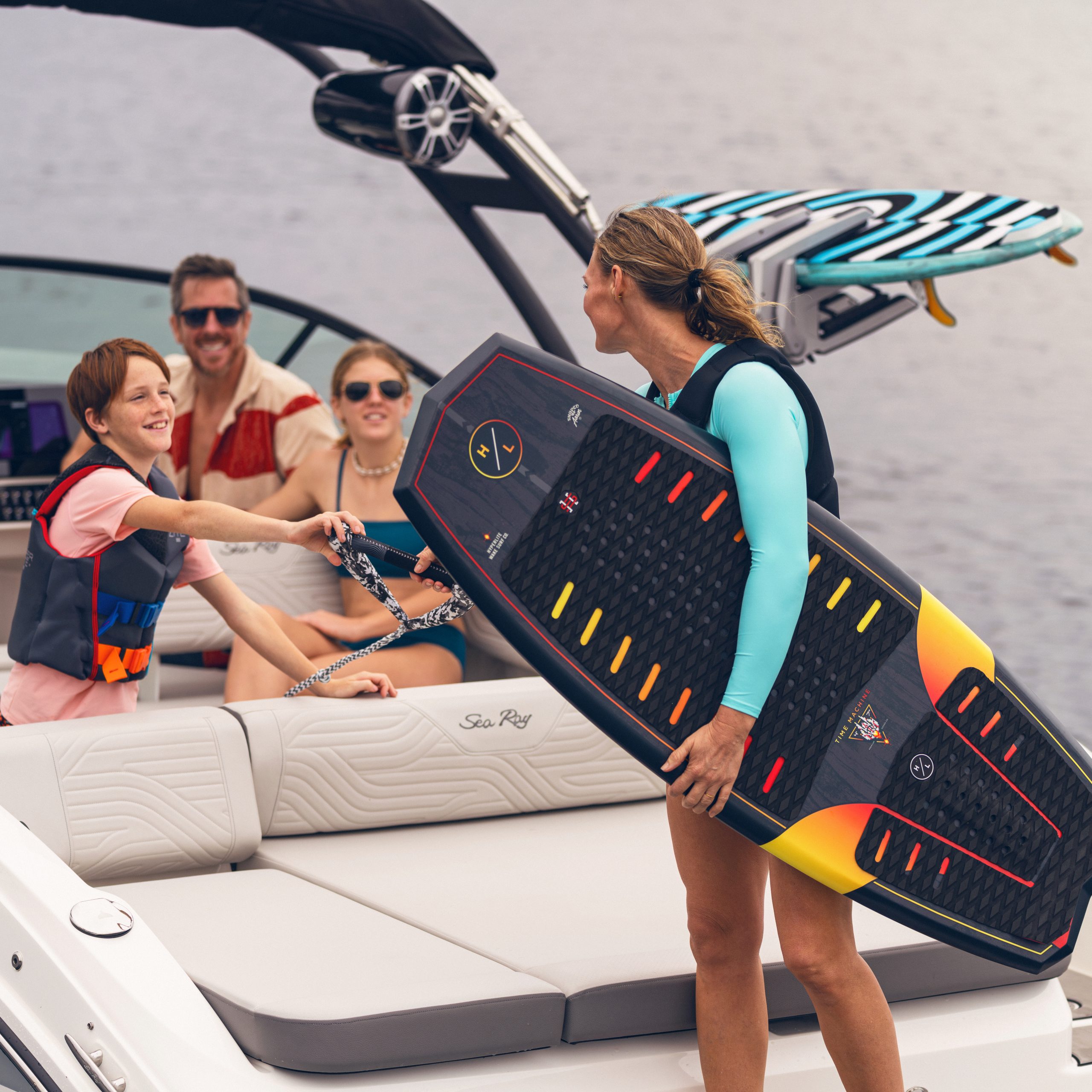 Woman aboard an SDX 270 Surf with her family preparing to go wakesurfing